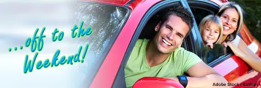 Photo: A happy family in a red car on their way to the weekend