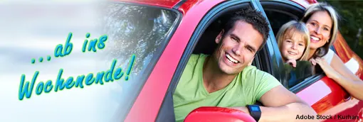 Foto: Eine glückliche Familie im roten Auto auf dem Weg in das Wochenende