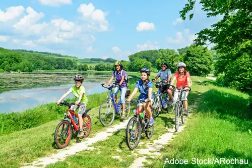 Foto: Eine Familie auf Fahrradtour entlang eines Sees