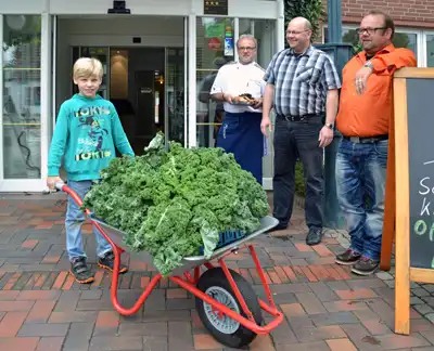 Foto: Die "Thomsen-Männer" präsentieren eine Schubkarre voll mit Grünkohl